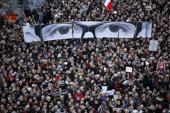 People hold panels to create the eyes of late Charlie Hebdo editor Stephane Charbonnier, known as "Charb", as hundreds of thousands of French citizens take part in a solidarity march (Marche Republicaine) in the streets of Paris